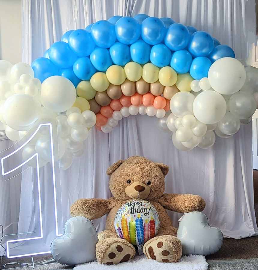 Birthday setup with balloons and teddy bear.