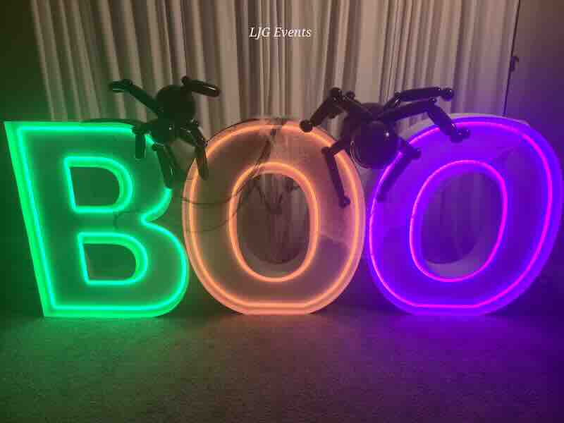 Neon BOO sign with inflatable spiders for Halloween.