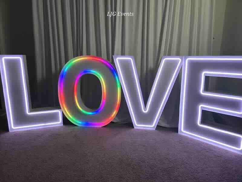 Illuminated letters spelling LOVE with rainbow colors.
