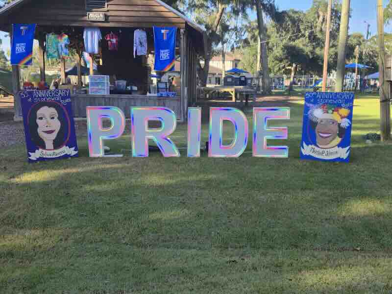 Colorful pride display with illustrations at outdoor event.