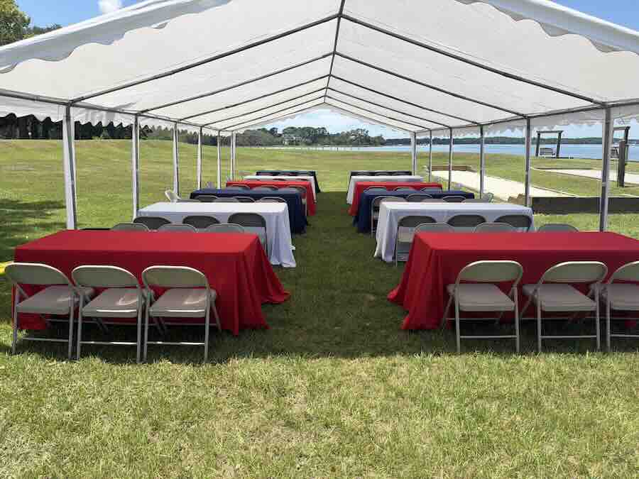 Outdoor event tent with tables by waterfront