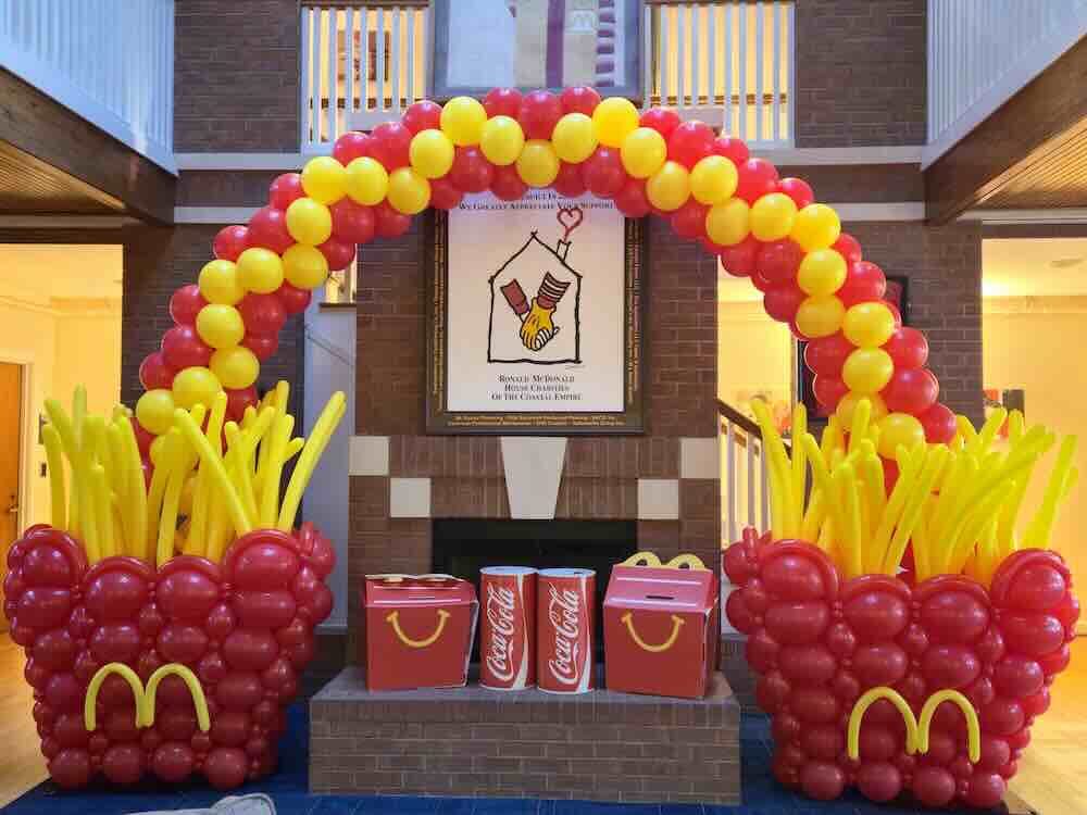 McDonald’s-themed balloon arch with fries, boxes, and Coca-Cola cans
