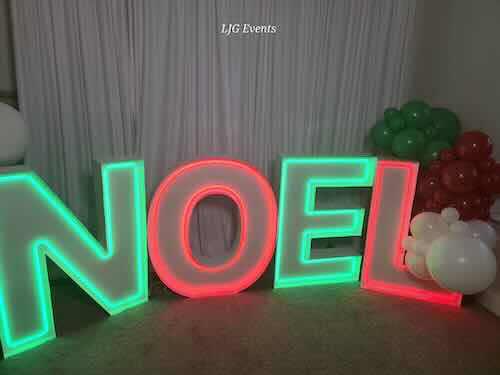 Illuminated NOEL sign with Christmas balloons.