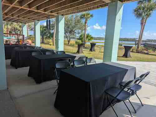 Outdoor event space with tables and chairs setup.