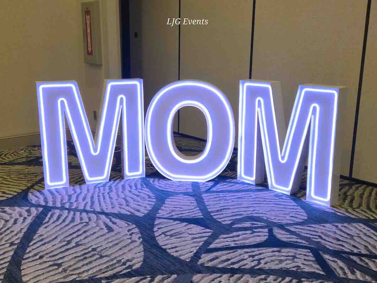 Large illuminated MOM letters at indoor event