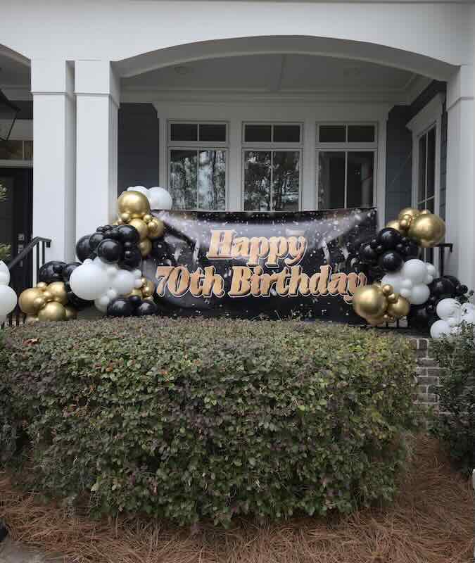70th birthday banner with balloons on porch