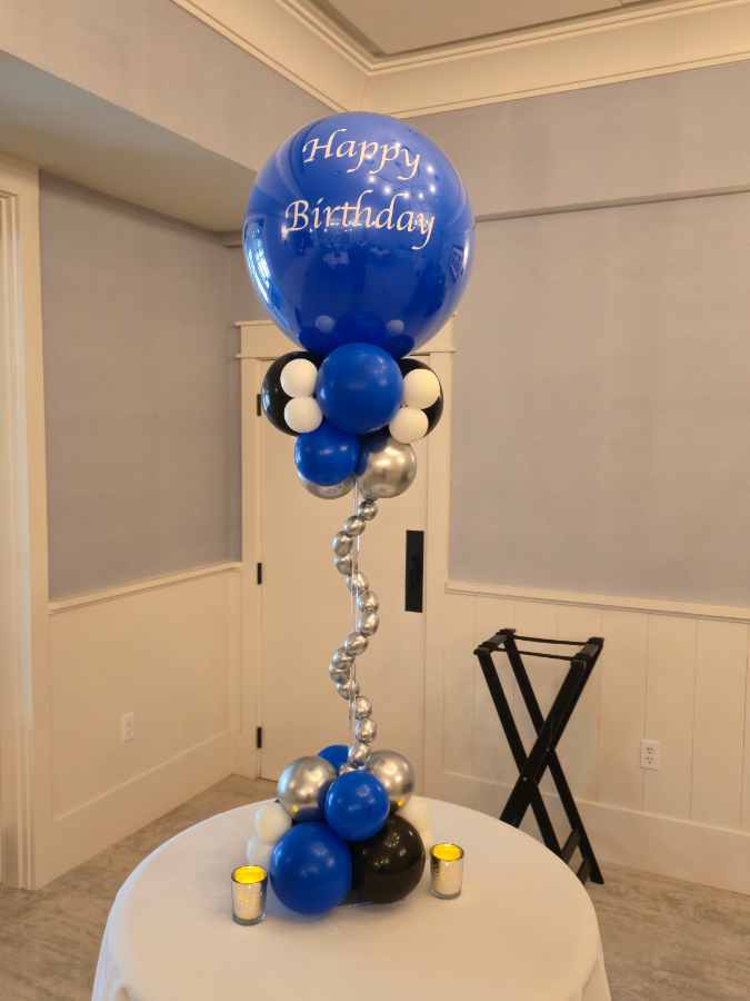 Happy Birthday balloon centerpiece on table