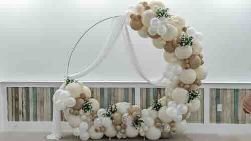 Balloon arch decoration with white and beige balloons.