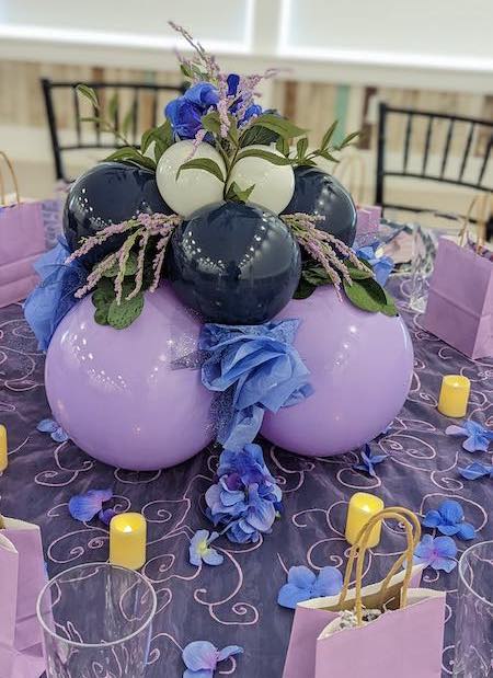 A beautiful purple and blue table setting at an event.