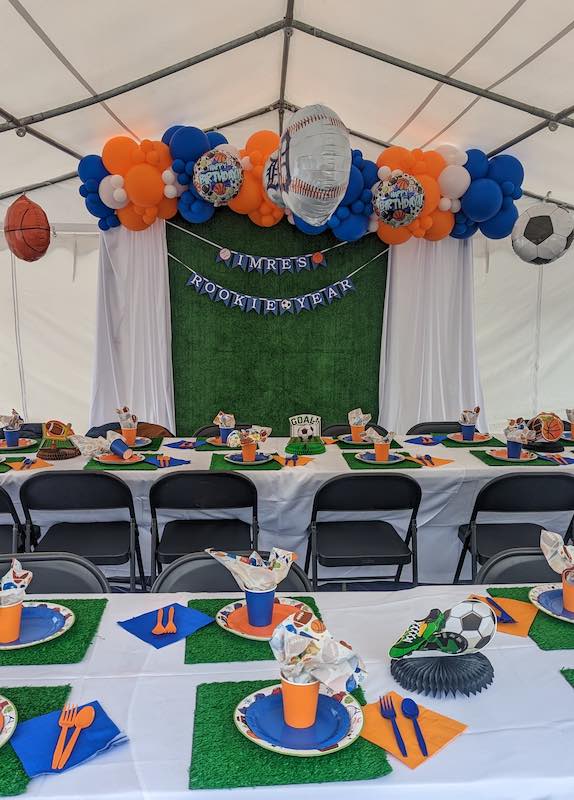 A football themed event that has similarly themed table settings with rented chairs, tables, and tent from LJG Events.