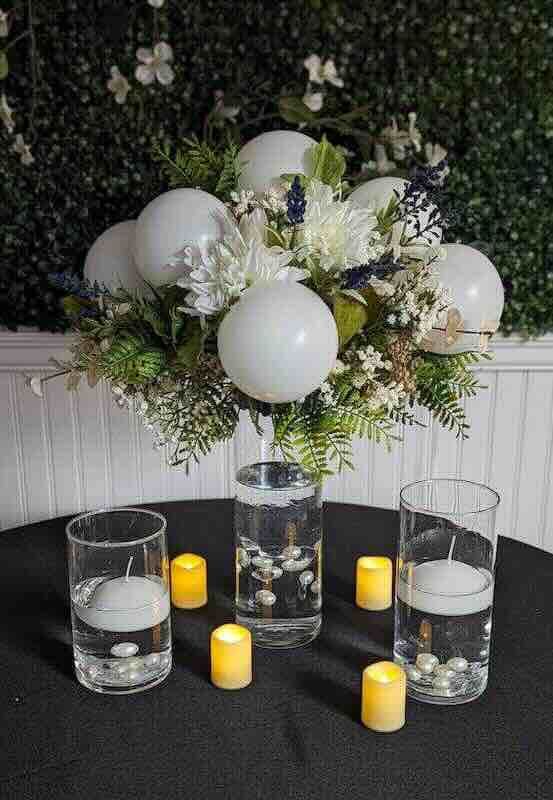 Elegant floral centerpiece with candles on table.